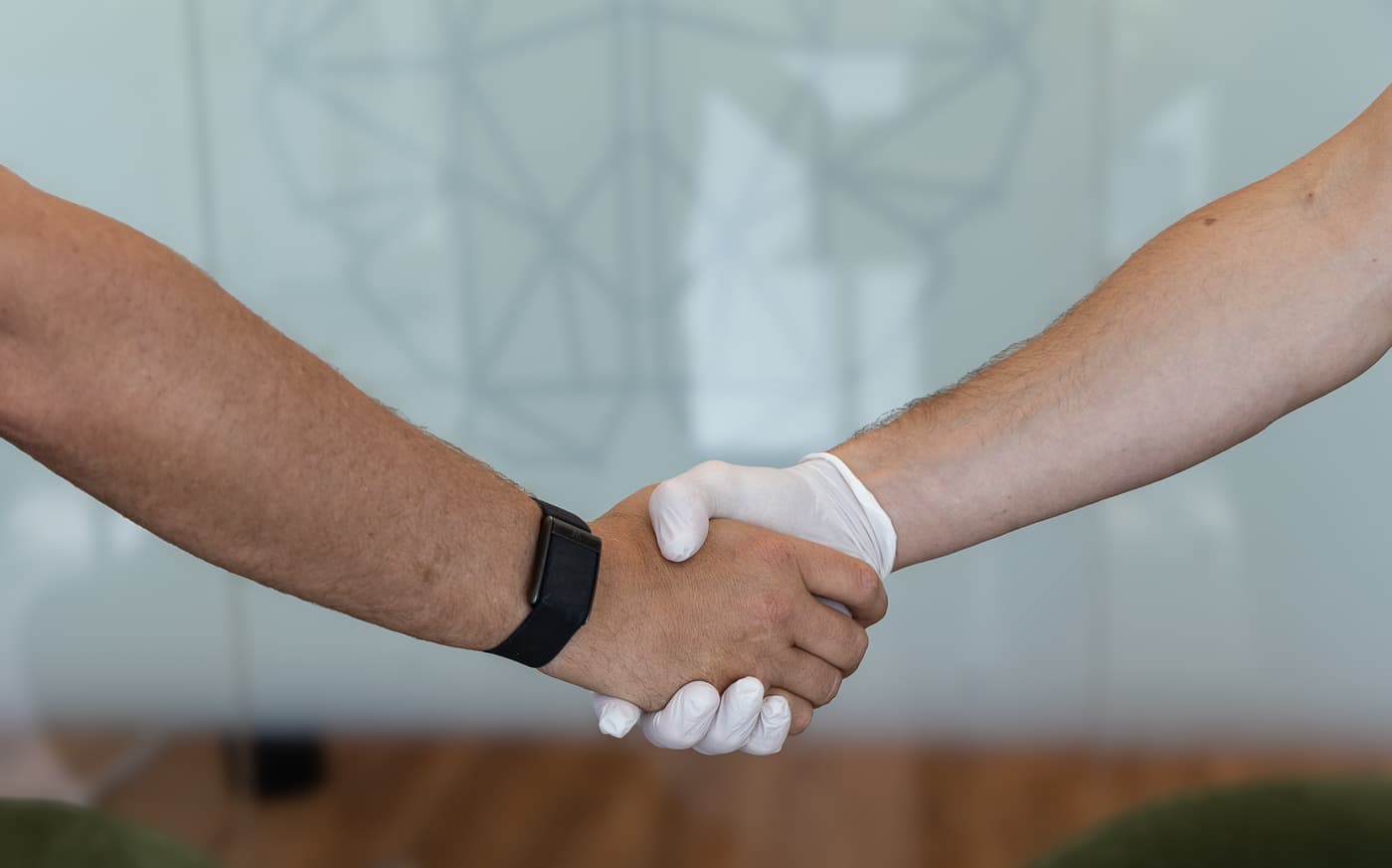 Twee zorgverleners schudden elkaar de hand in de kliniek